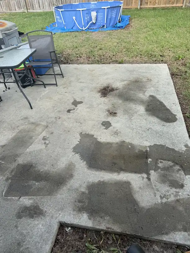 A backyard clearance with a pool liner, patio furniture and a bare concrete pad