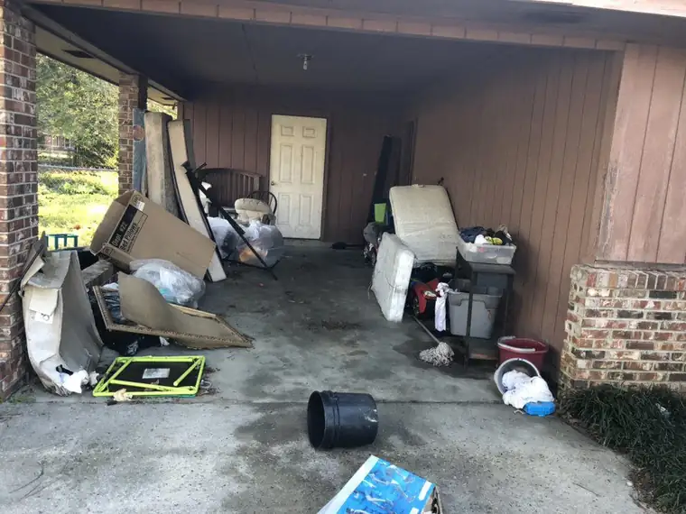 Carport packed wall to wall with household junk before clearance
