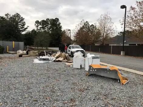 A commercial gravel lot strewn with scrap metal and fixtures before pickup